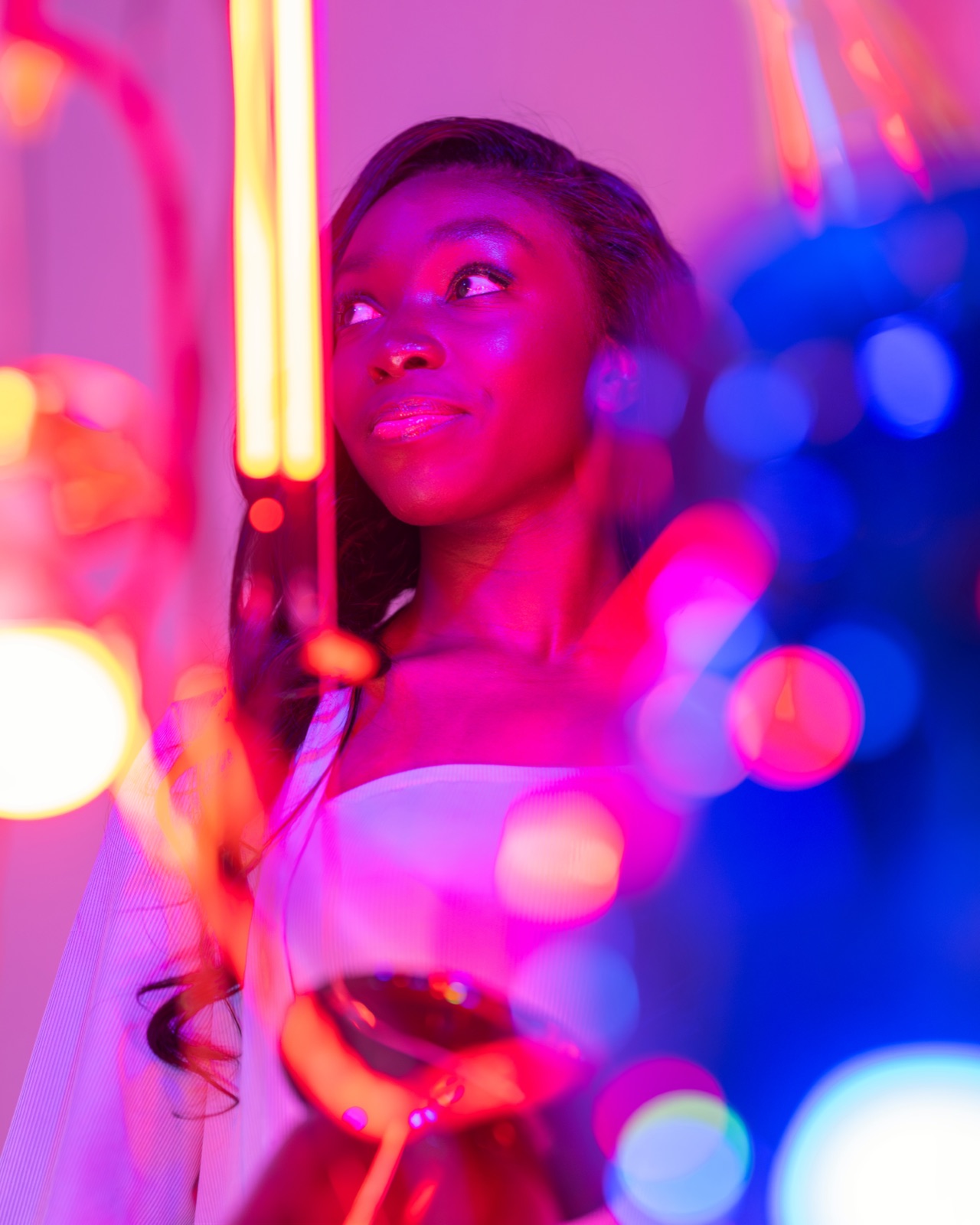 Atmospheric neon-light editorial, white top, magenta and amber