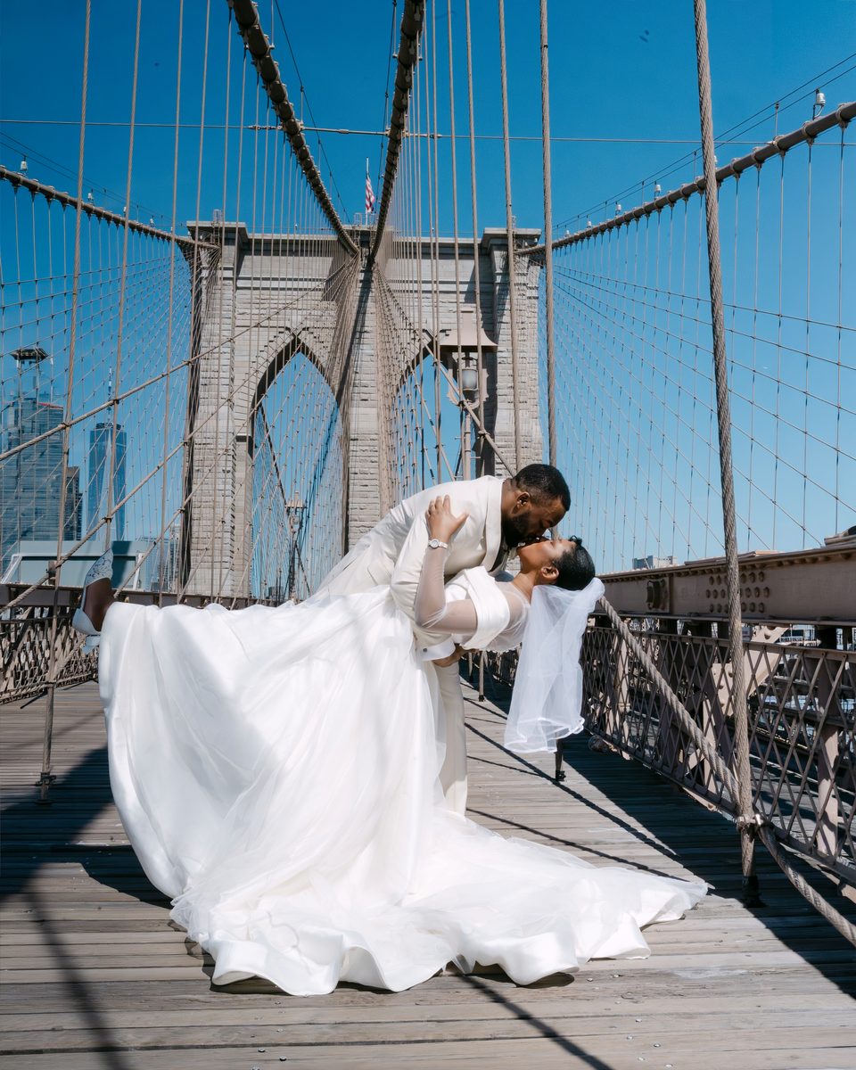 Groom dips the bride on the Brooklyn Bridge