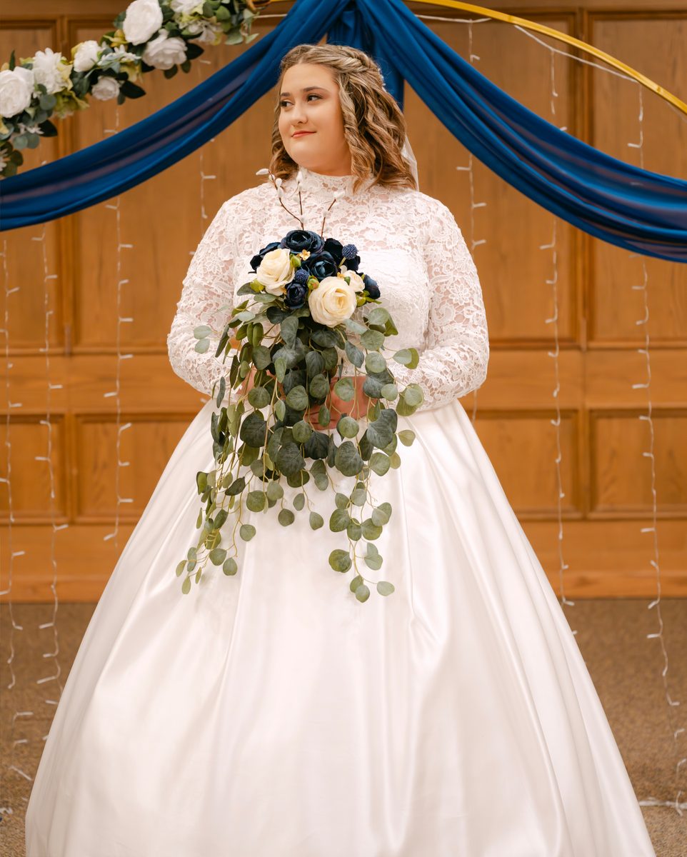 Bride in a high lace collar with a navy and white bouquet