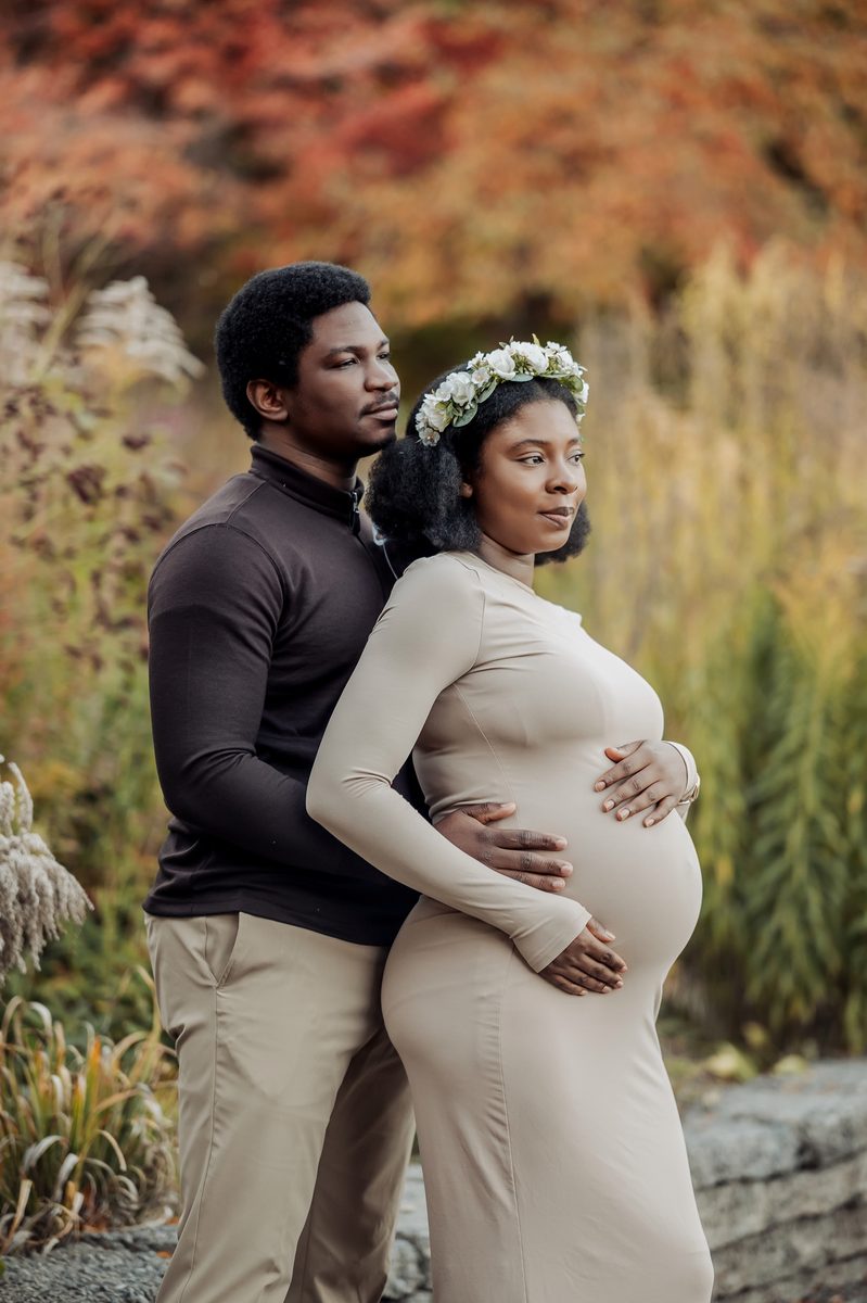 Expecting couple among autumn grasses