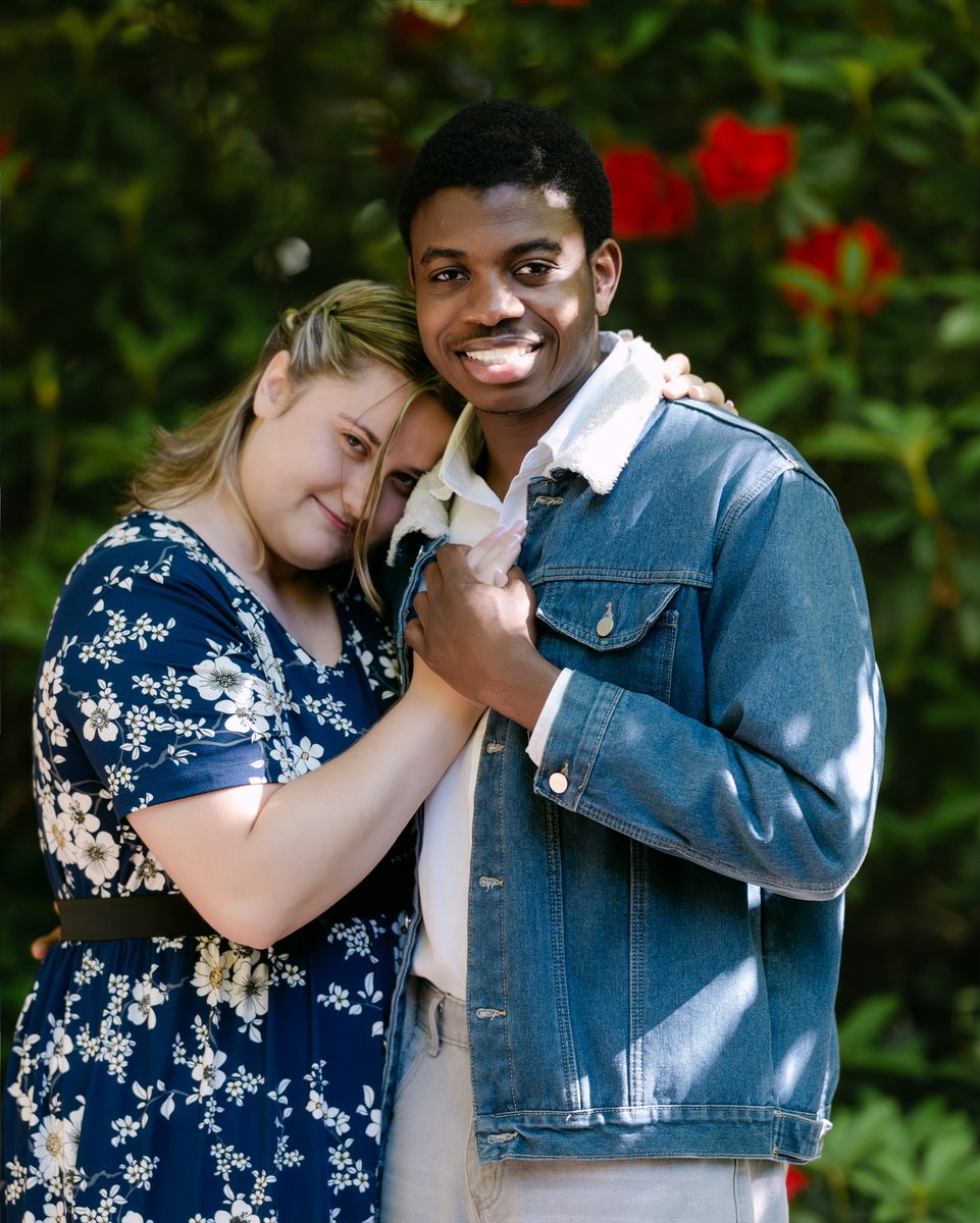 Couple in denim and florals, smiling in a garden