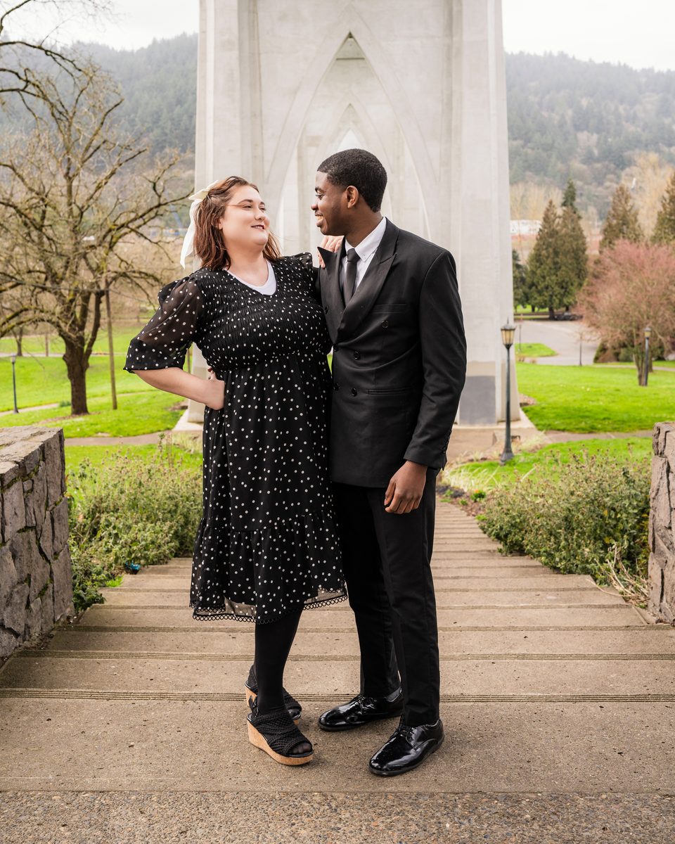 Couple on a path beneath a gothic-arched bridge