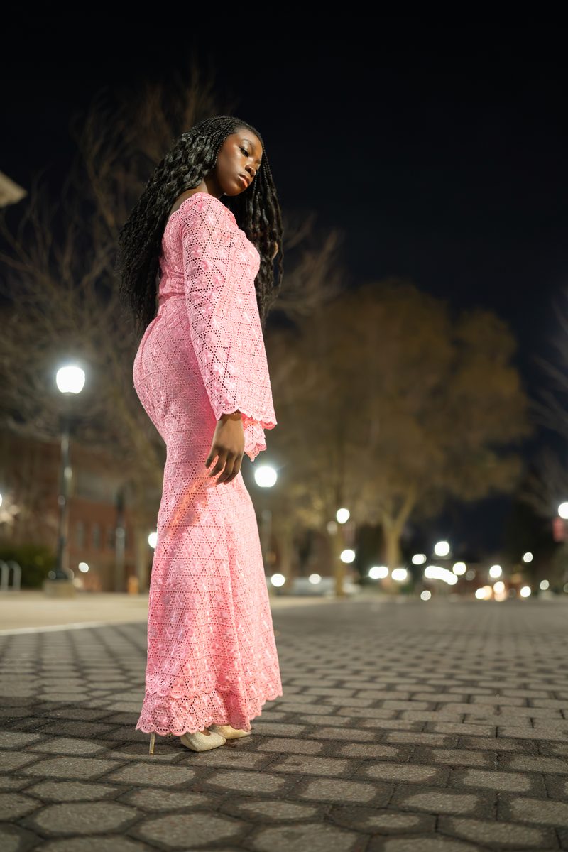 Pink lace gown on a lamplit plaza at night