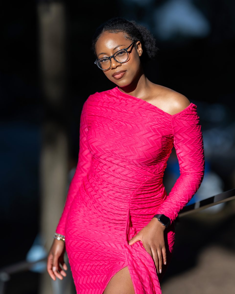 Fuchsia off-shoulder dress against dark pines