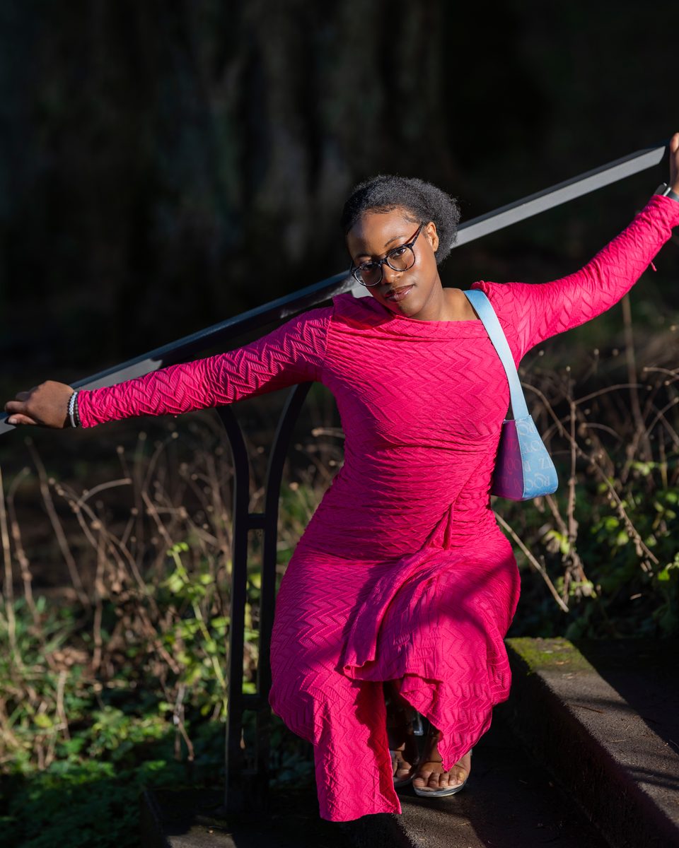 Fuchsia dress, leaning back on a stair rail in the forest