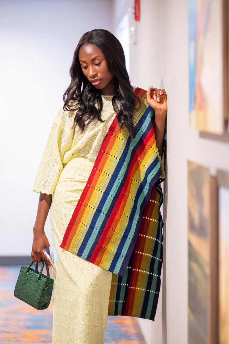 Kente shawl and green handbag in a hotel corridor