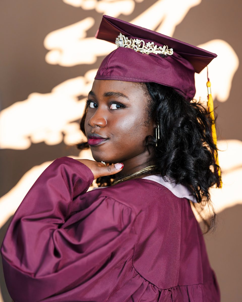 Over-the-shoulder look in a maroon gown and cap