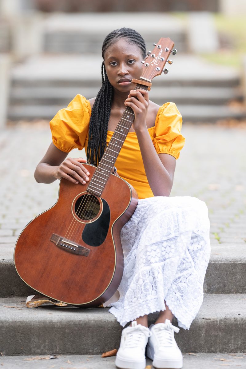 Yellow top and guitar on stone steps