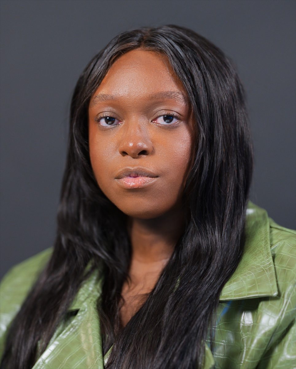 Close portrait in an olive leather coat on black