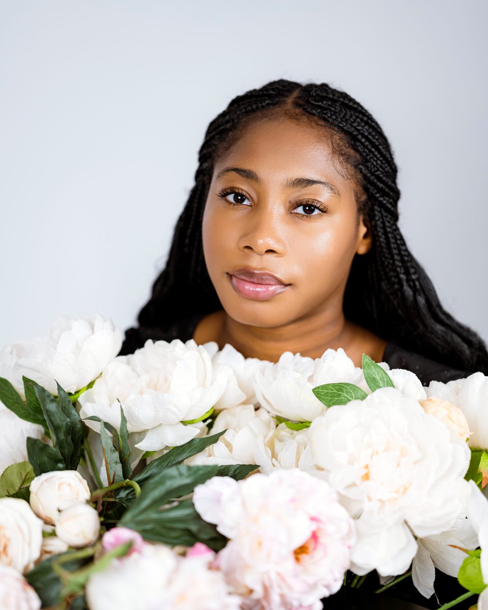 Portrait above a bed of white peonies