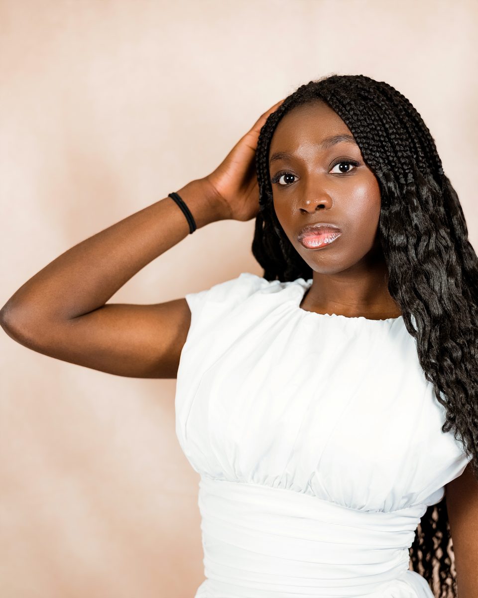 White dress, hand in hair, warm mottled backdrop