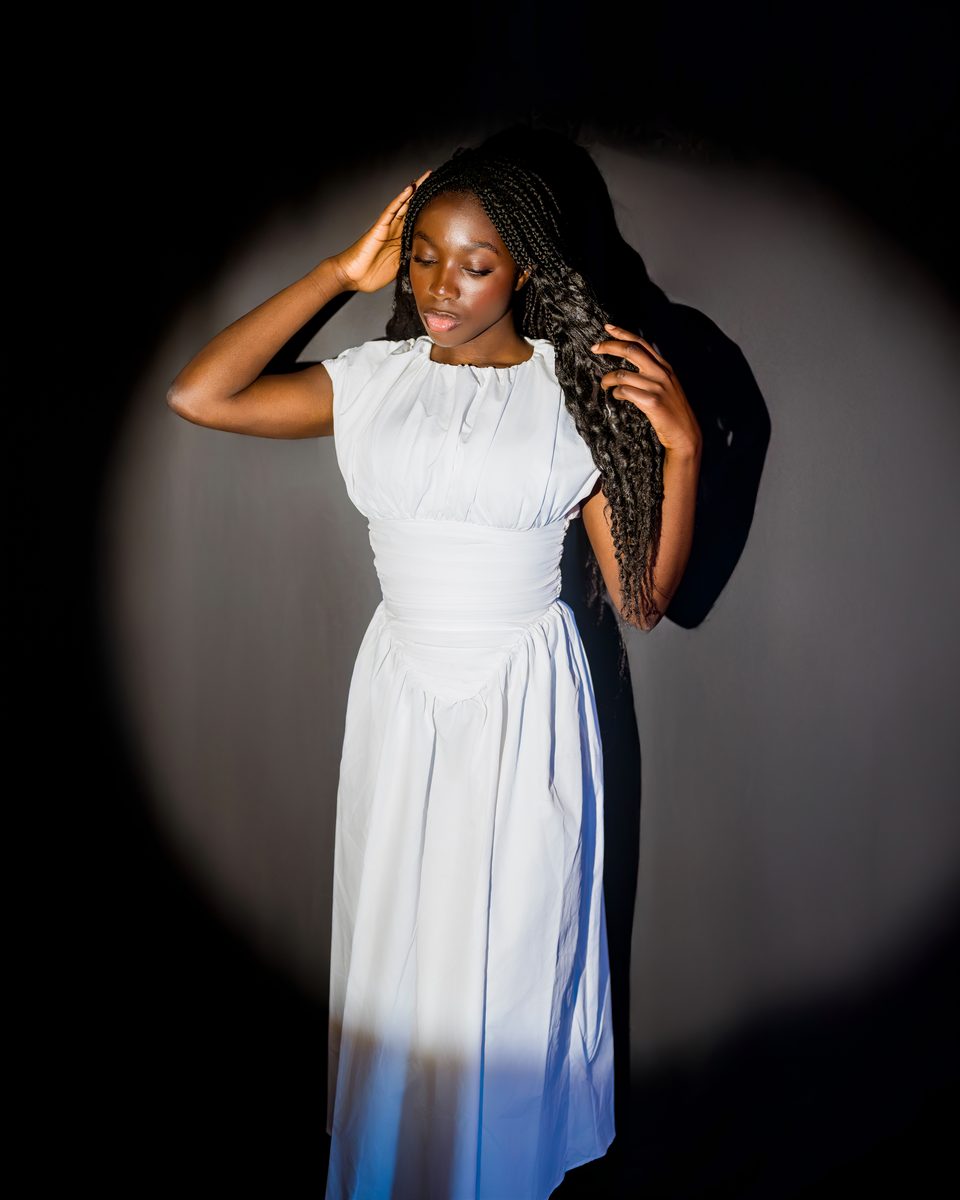White dress in a spotlight on a black backdrop
