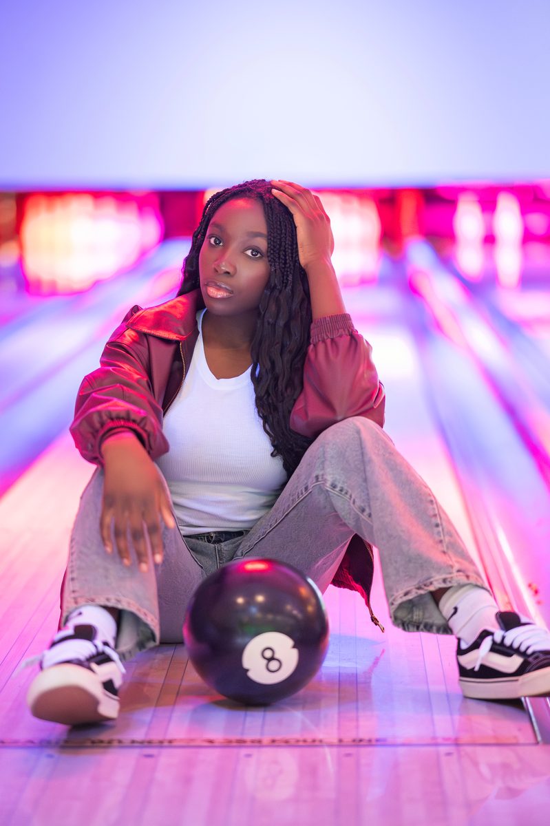 Seated on a bowling lane with an eight ball
