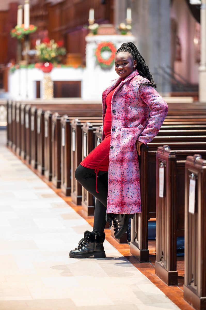 Pink patterned coat between cathedral pews